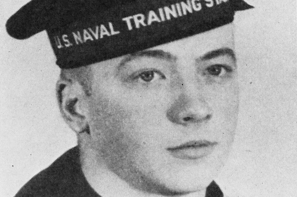 Black and white portrait of a young person wearing a U.S. Naval Training Station hat. The individual, likely involved in DOD cybersecurity efforts, is in uniform and looking slightly to the side with a neutral expression.