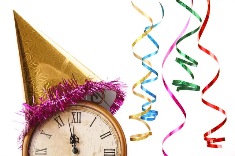 A festive scene with a clock showing a few minutes to midnight, adorned with a golden party hat with pink tinsel. Colorful curling ribbons in gold, red, green, and blue hang alongside, creating a celebratory atmosphere likely for New Year's Eve. One can't help but think of DOD's heightened vigilance against cyberthreats as we enter the new year.