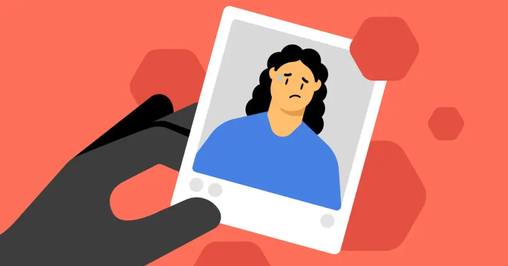 A black gloved hand is holding a photograph of a person with long black hair, wearing a blue shirt. The person in the photograph looks distressed with a sweat drop on their forehead. The background is red with abstract red hexagons, evoking an imminent cyberthreat.