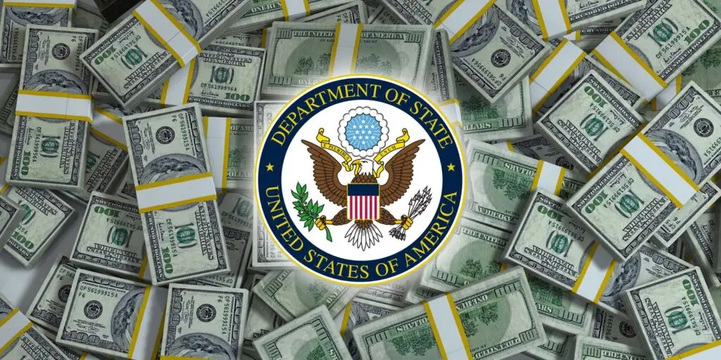 Stacks of U.S. 100-dollar bills surround a logo of the U.S. Department of State, featuring an eagle with a shield, arrows, and olive branches. In the background, an abundance of money subtly underscores the importance of DOD investments and CMMC compliance in bolstering national cybersecurity.