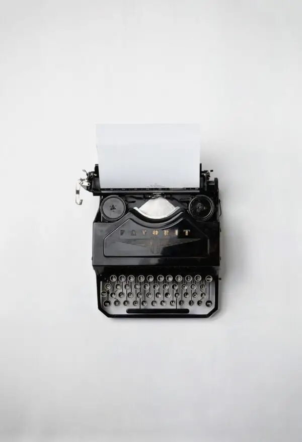 A black vintage typewriter with the word "FAVORIT" on top sits against a plain white background, symbolizing a simpler time before the rise of sophisticated cybersecurity threats. A blank sheet of paper is partially inserted in the machine, reminding us how far we've come in safeguarding our digital age.